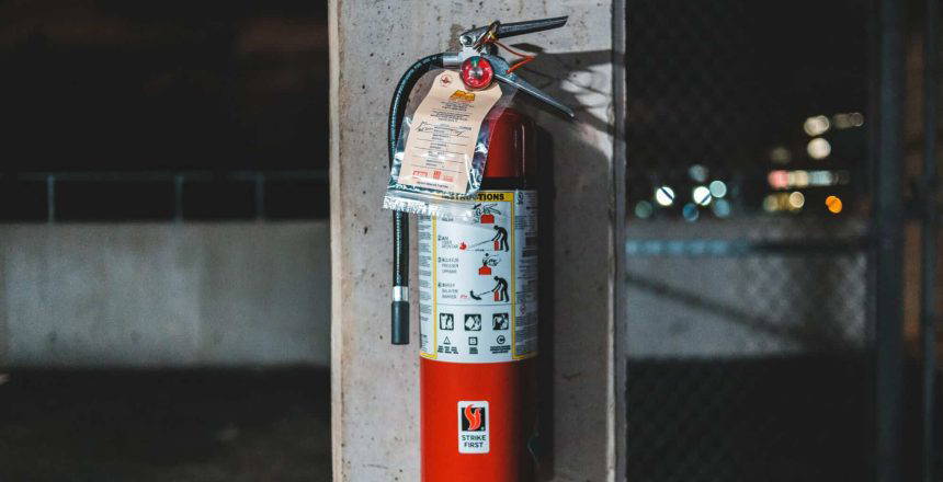 Fire extinguisher attached to stone pillar